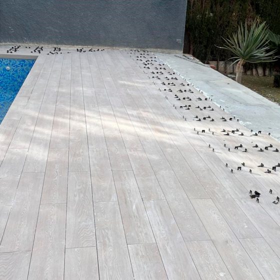 reforma de terraza de piscina con gres porcelánico imitación madera e iluminación de piscina en Urbanización Cruz de Gracia, Paterna, Valencia por Mediterranean Pool