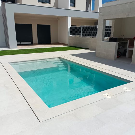 Construcción de piscina de obra y gunitada con escalera de obra, zona de chapoteo, gres porcelánico, terraza y depuradora con electrólisis salina y sistema de limpieza automático net'n'clean torrent, torrente, Valencia por Mediterranean Pool