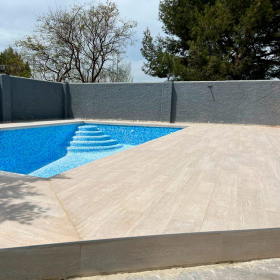 reforma de terraza de piscina con gres porcelánico imitación madera e iluminación de piscina en Urbanización Cruz de Gracia, Paterna, Valencia por Mediterranean Pool
